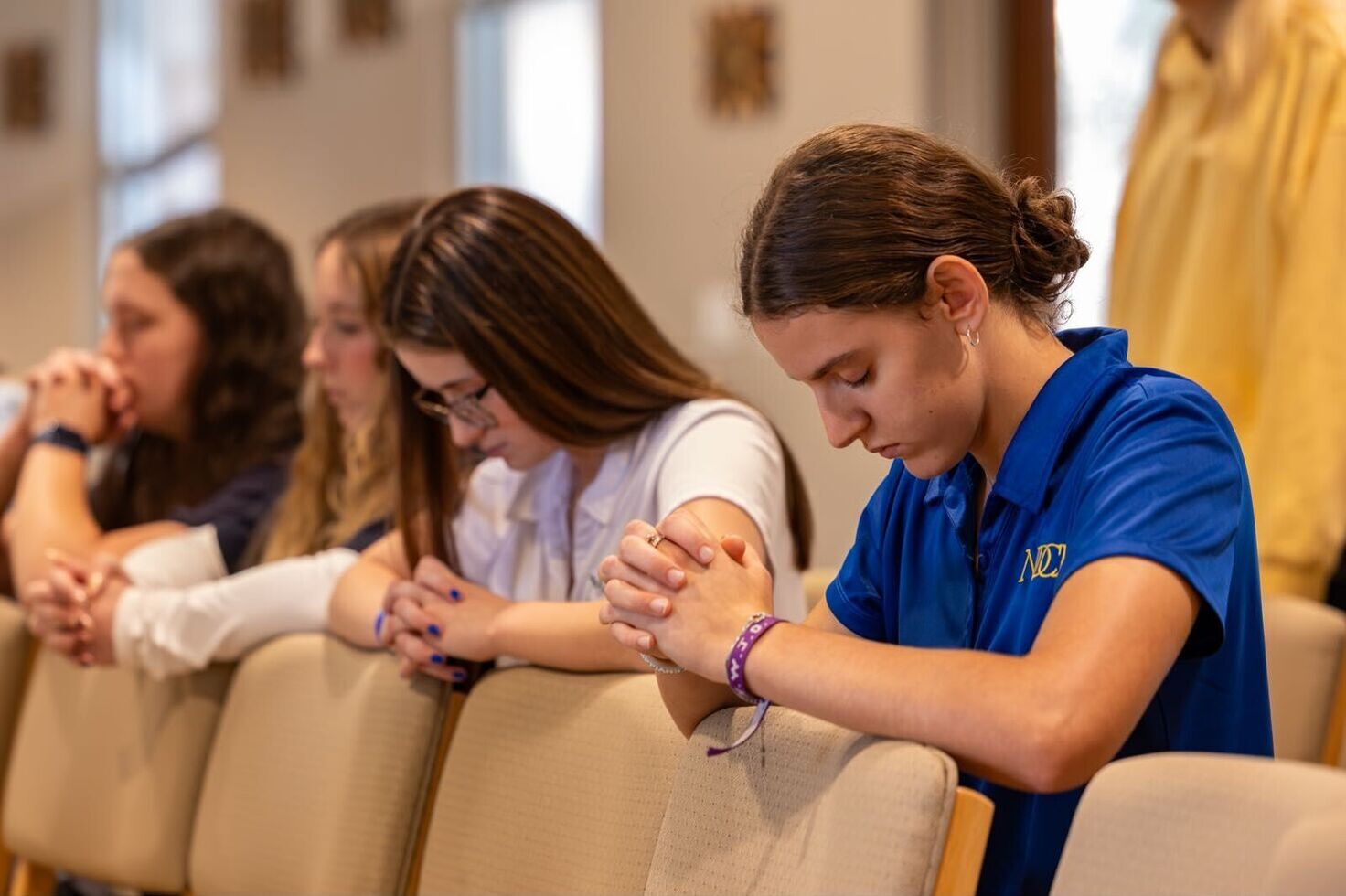 students kneeling in prayer